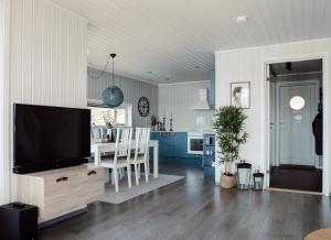 a living room with a television and a dining room at Malangen Resort in Mestervik
