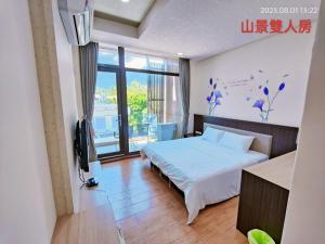 1 dormitorio con cama y ventana grande en Dulan Pearl Hill Homestay en Donghe