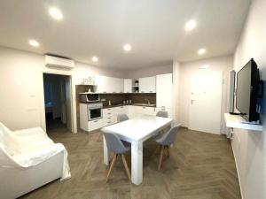 a white kitchen with a white table and chairs at Casa Daniela in Naples