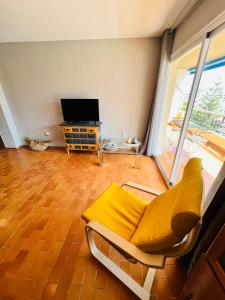 uma sala de estar com um sofá amarelo e uma televisão em Torremolinos CARIHUELA Núcleo Cristal em Torremolinos