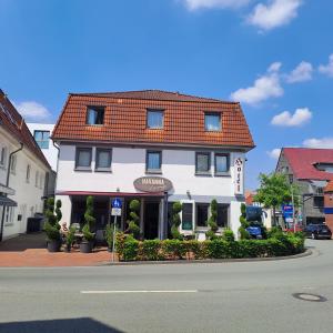 un edificio blanco con techo rojo en una calle en Hotel Ammerländer Hof, en Westerstede