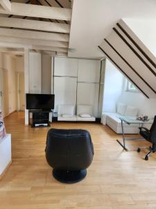 a living room with a black chair and a television at villa high ceiling 2 bedrooms in Troisdorf