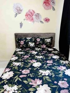 a bedroom with a bed with flowers on the wall at Cozy 2 bedroom Home 10 min from Airport in San Luis