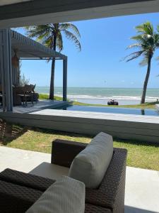 a patio with a couch and a view of the ocean at Club de Mar Condo Hotel in Icaraí