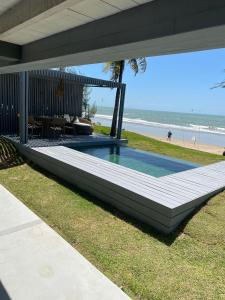 a house with a swimming pool next to the beach at Club de Mar Condo Hotel in Icaraí