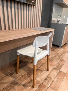 una sedia bianca seduta al bancone in cucina di Ayres Apart Hotel a Federal
