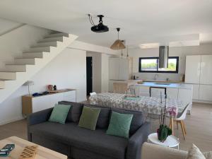 a living room and kitchen with a couch and a table at Magnifique Villa, Piscine, Proche Plage, 8 personnes in Lansargues