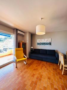 uma sala de estar com um sofá azul e uma cadeira amarela em Torremolinos CARIHUELA Núcleo Cristal em Torremolinos