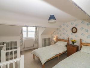 1 dormitorio con 2 camas y ventana en Panoramic Cottage en Brixham
