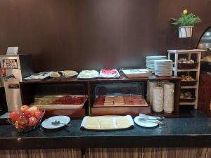 a buffet line with cheese and other food on a counter at Hotel Diego de Almagro Curicó in Curicó