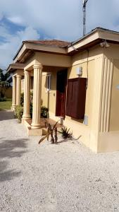 a house with pillars on the side of it at Luxury one bed room apartment in Nassau