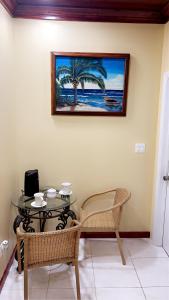 a table and chairs with a picture on the wall at Luxury one bed room apartment in Nassau