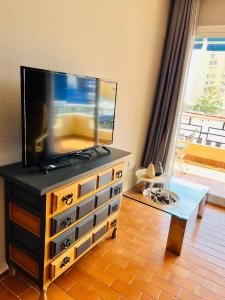 uma sala de estar com uma televisão de ecrã plano numa cómoda em Torremolinos CARIHUELA Núcleo Cristal em Torremolinos