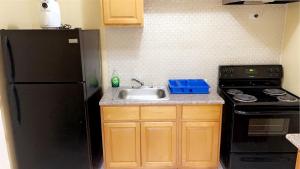 a kitchen with a sink and a black refrigerator at Luxury one bed room apartment in Nassau