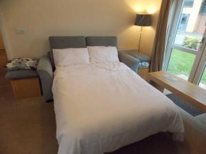 a bedroom with a large white bed and a couch at Spacious Ground Floor Flat in Buckinghamshire