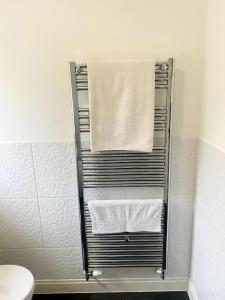 a towel rack with towels on it in a bathroom at Spacious Ground Floor Flat in Buckinghamshire
