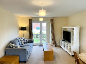 a living room with a couch and a tv at Spacious Ground Floor Flat in Buckinghamshire