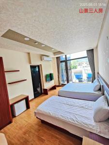 Cette chambre comprend 2 lits et une fenêtre. dans l'établissement Dulan Pearl Hill Homestay, à Donghe