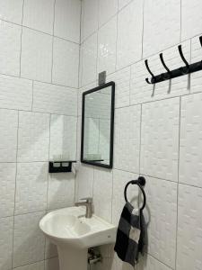 ein weißes Badezimmer mit einem Waschbecken und einem Spiegel in der Unterkunft TREAT HOMIES in Kira