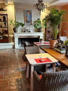 a living room with a fireplace and a table and chairs at Hostellerie Les Hauts De Sainte Maure in Sainte-Maure-de-Touraine