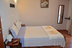 a bedroom with a bed with a blue and white comforter at Agyra Studios in Vasilika