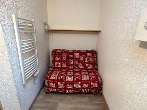 a small room with a red bed in a room at Studio cosy au pied des pistes avec balcon, proche centre et piscine, navette gratuite - FR-1-515-172 in Villard-de-Lans