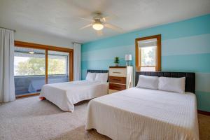 2 letti in una camera da letto con pareti blu e finestra di Lakefront Syracuse Home with Deck and Private Dock! a Syracuse