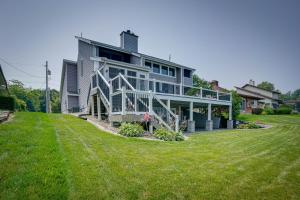 a large house on top of a grassy hill at Lakefront Syracuse Home with Deck and Private Dock! in Syracuse