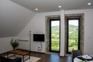a living room with two windows and a tv at Quinta do Bairro in Vieira do Minho