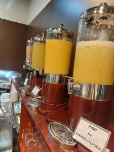 un mostrador con tres tarros de zumo de naranja en Hotel Diego de Almagro Talca Express, en Talca