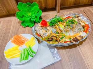 une table avec deux plats de nourriture et une assiette de légumes dans l'établissement Bai Chay Panda Hotel, à Hạ Long