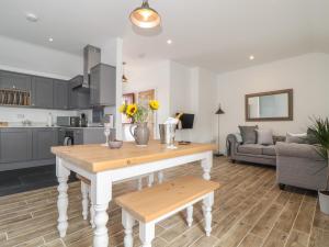 eine Küche und ein Wohnzimmer mit einem Tisch und einem Sofa in der Unterkunft Foxglove Barn in Penzance