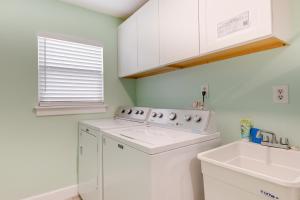 a white laundry room with a washer and a sink at Waterfront Jacksonville Retreat with Boat Dock! in Jacksonville +20 photos