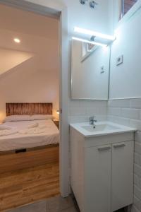 a bathroom with a white sink and a bed at New 1 min Metro, cozy 1 bed close to Downtown, wifi A in Madrid