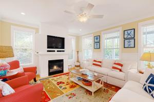 a living room with white furniture and a fireplace at Olivia's Rose in Lincoln City