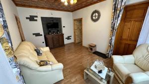 a living room with two couches and a tv at Apartament Władek in Biały Dunajec