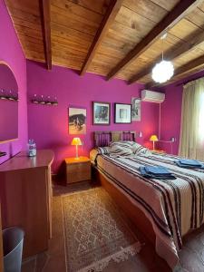 a bedroom with purple walls and a large bed at Casa Rural Zinho in Arenas