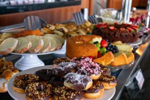 a display of different types of donuts and pastries on plates at Hotel Senac Ilha do Boi in Vitória