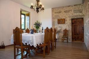 ein Esszimmer mit einem Tisch, Stühlen und einem Kronleuchter in der Unterkunft Quinta do Bairro in Vieira do Minho