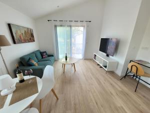 a living room with a couch and a tv at cosy, spacieux, avec balcon, au calme in Artigues-près-Bordeaux