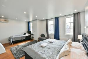 ein Schlafzimmer mit einem Bett, einem Sofa und Fenstern in der Unterkunft LUXURY CENTRAL DUPLEX WITH TERRACE in Prag