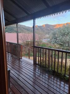 a deck with a view of the mountains at Mystic Mountain Cottage in Clarens