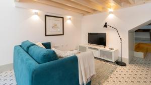 a living room with a blue couch and a tv at Central Stunning Duplex w/ Patio by LovelyStay in Porto