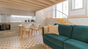 a living room with a blue couch and a kitchen at Central Stunning Duplex w/ Patio by LovelyStay in Porto