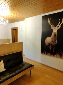 a living room with a painting of a deer on the wall at Gstattlhof Mountain Lodge in Braies