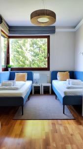 Zimmer mit 2 Betten und einem großen Fenster in der Unterkunft Casa Harmony Tata in Tata