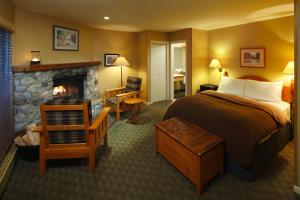 Emerald Lake Lodge في فيلد: غرفة فندقية بها سرير وموقد