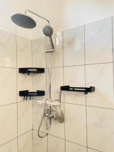 a shower with a shower head in a bathroom at Mufasa city Hostel and Apartments in Arusha