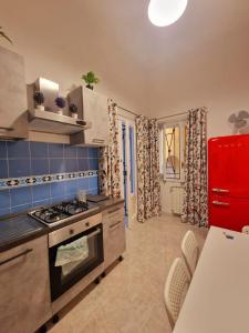 a kitchen with a stove and a red refrigerator at CAROLINA'S LOFT in Caserta +9 photos
