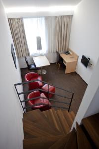 a hotel room with a red chair and a desk at Apart2stay in Luxembourg